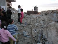 Children playing close to one of the many watchtowers around Rafah. Extreme danger has become part of everyday life. In March 2003, Tom Hurdall, an ISM activist, tried to get some children to leave a particularly dangerous area. He was wearing the ISM activists orange vest. He was killed by a shot in the head.