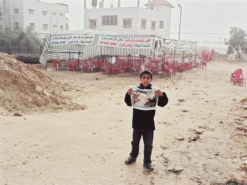 The morning after the funeral party. The boy is holding on of the posters that were produced to honor the memory of Rachel.