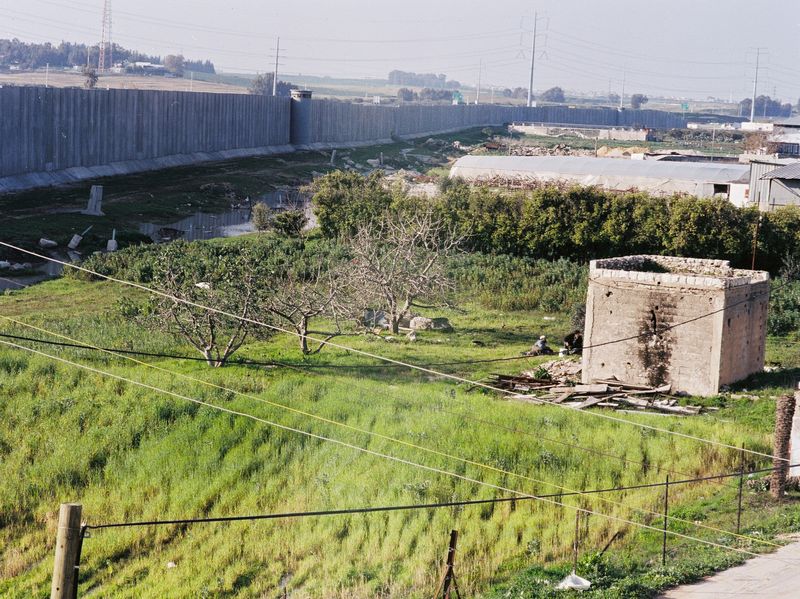 The wall is dividing the land of Palestinian farmers and houses are destroyed by bulldozers as well as by construction workers blowing up rocks to make way for the wall. A repeated scenario: the demolishing of houses creates a no mans land. The "no mans land" is then annected and turned to Israeli land. Then a security zone is required to protect the land ......