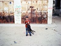 A boy with a kite made of an umbrella.