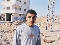 The families had to abandon the house in the background. The young man is a neighbour living 40 meters away.