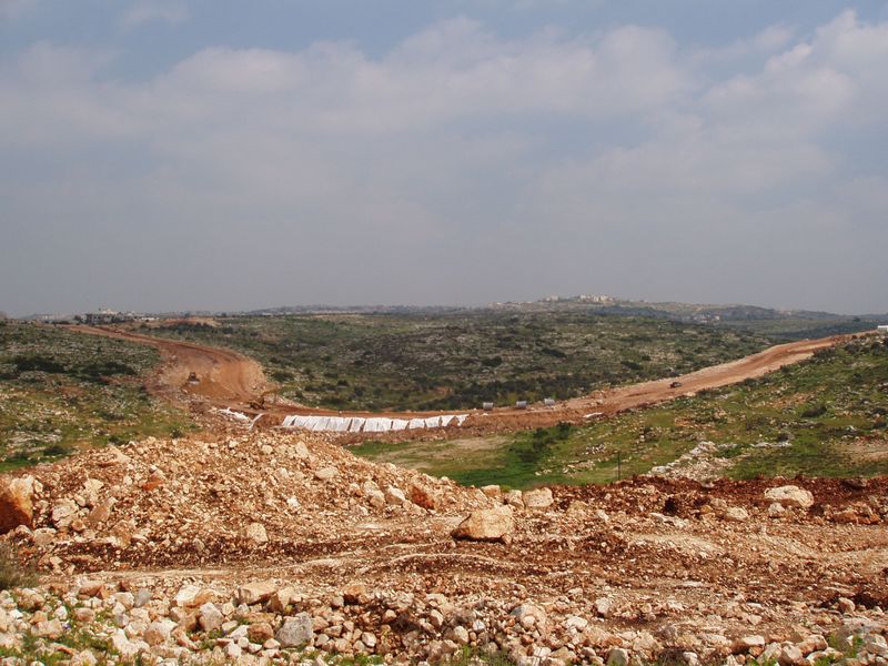 Ras Atiya.  A wide scar running through the landscape separates the village from most of its agricultural land.