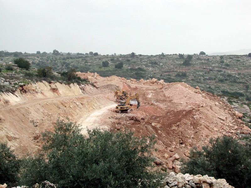 Heavy machines work long hours to clear the ground for the wall. 
