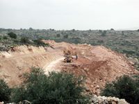 Heavy machines work long hours to clear the ground for the wall. 