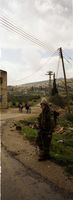 Israeli soldier guarding the entrance to a village.